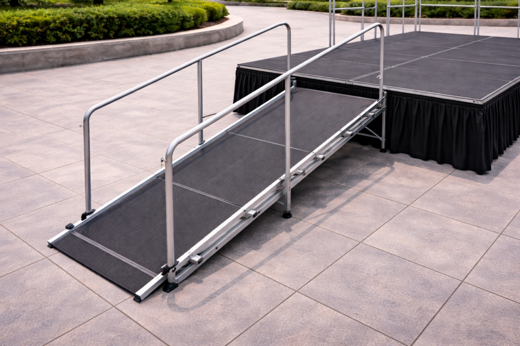 Rampa de acceso para tarima modular en escenario municipal, con estructura metálica y superficie antideslizante para accesibilidad